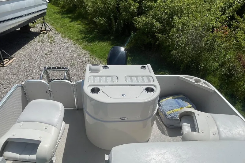 Slide: The Image of 2007 Premier 231 Alante pontoon boat interior with seating and steering wheel, parked outdoors. - 21