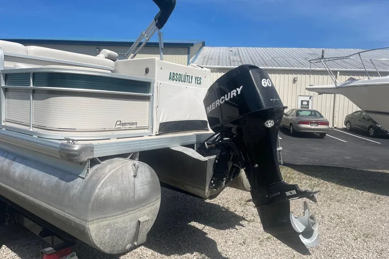 Slide: The Image of 2007 Premier 231 Alante pontoon boat with Mercury outboard motor, parked on gravel. - 4