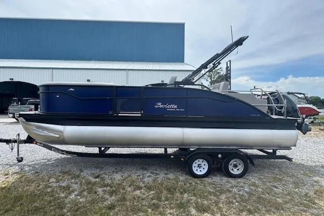 Slide: The Image of 2026 Barletta ARIA 22UC pontoon boat on trailer, parked outdoors. - 6