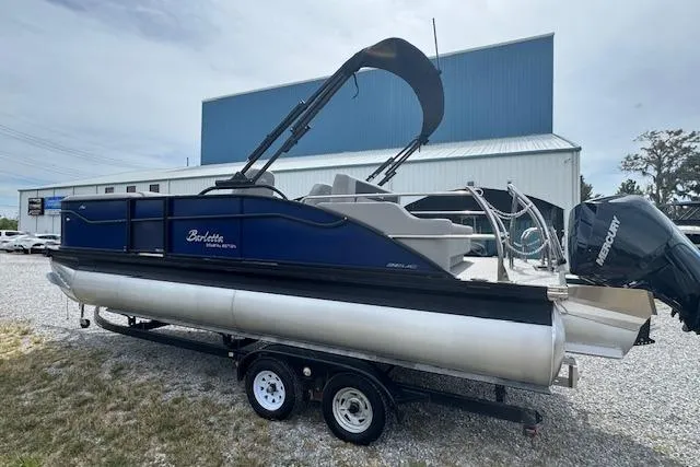 Slide: The Image of 2026 Barletta ARIA 22UC pontoon boat on trailer, blue and silver design. - 7