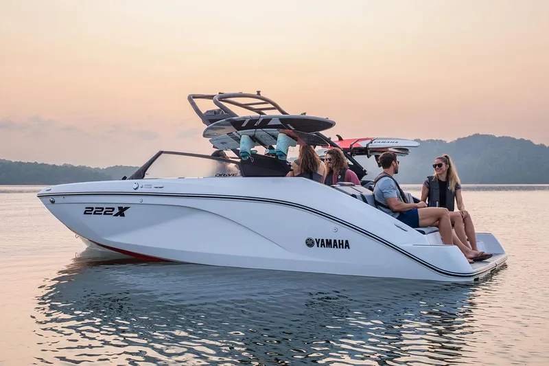 Slide: The Image of Manufacturer Provided Image: 2026 Yamaha Boats 222XE on serene water at sunset with passengers enjoying the ride. - 1