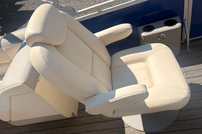 Slide: The Image of Luxurious cream leather seat on 2022 Lexington 524 boat, featuring armrests and cup holders. - 11