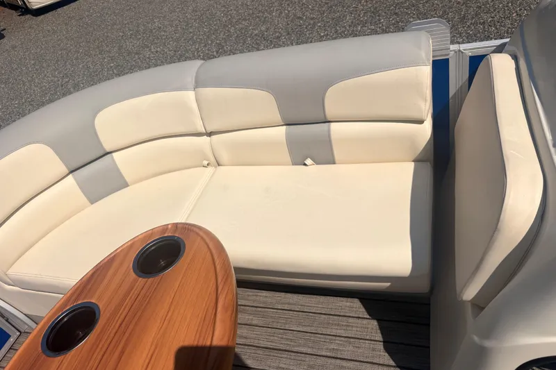 Slide: The Image of Luxurious seating on 2022 Lexington 524 boat with wooden table and cup holders. - 13