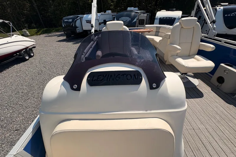 Slide: The Image of 2022 Lexington 524 boat interior with seating and windshield, parked outdoors. - 15