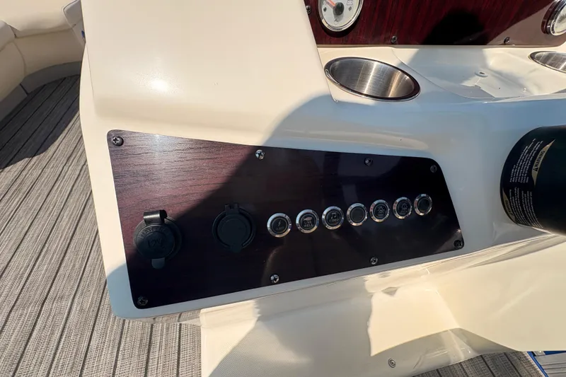 Slide: The Image of Control panel of 2022 Lexington 524 boat with switches and cup holders. - 17