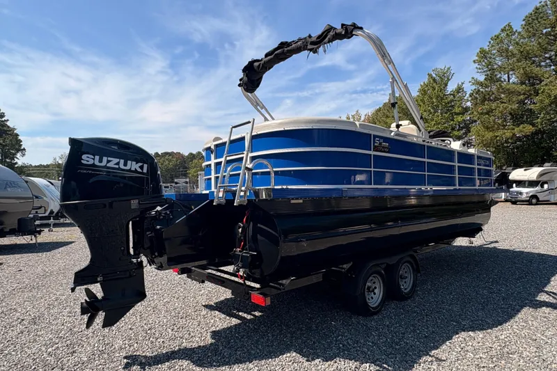 Slide: The Image of 2022 Lexington 524 pontoon boat with Suzuki outboard motor in a parking lot. - 4