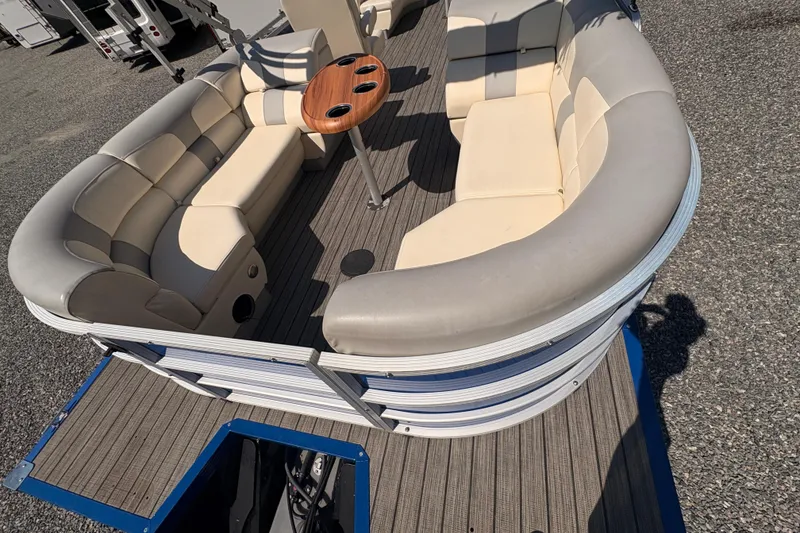 Slide: The Image of 2022 Lexington 524 pontoon boat with beige seating and wooden table on deck. - 7