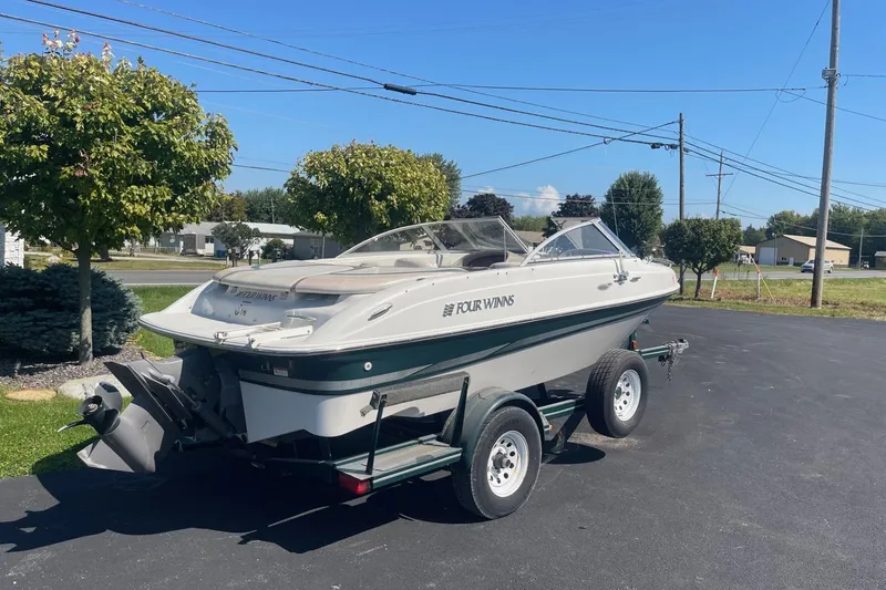 Slide: The Image of 2003 Four Winns 180 Horizon boat on trailer, parked outdoors on sunny day. - 3