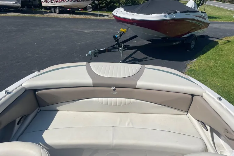 Slide: The Image of 2003 Four Winns 180 Horizon boat interior with cushioned seating, parked on a driveway. - 5