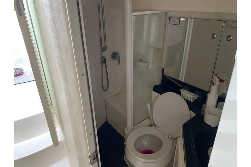 Slide: The Image of Bathroom interior of 1999 Wellcraft 45 Excalibur boat, featuring shower and toilet. - 4