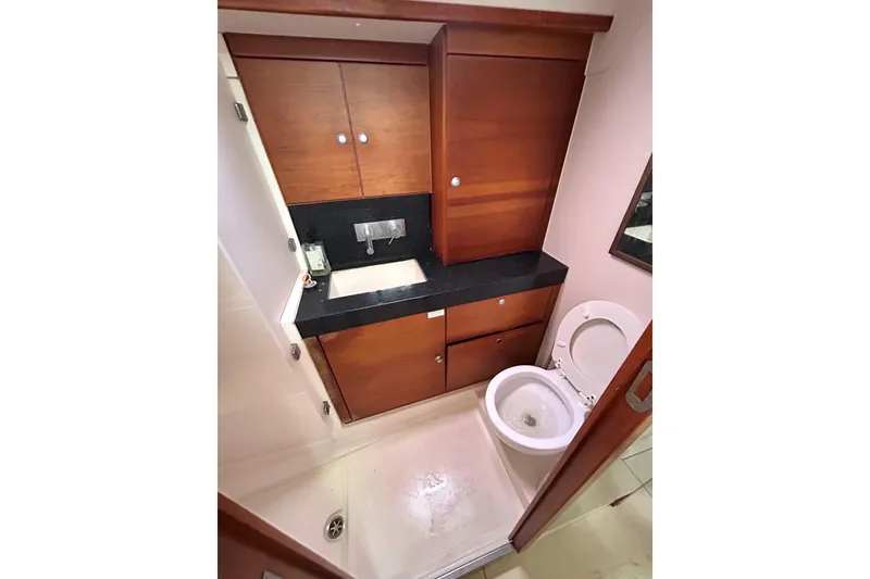 Slide: The Image of 2008 Hanse 470e yacht kitchen with wood cabinetry, black countertops, and modern appliances. - 13