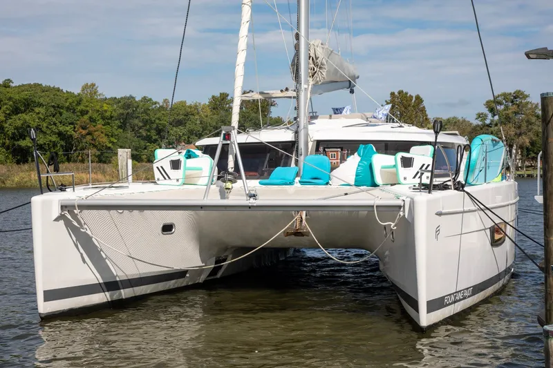 Slide: The Image of 2018 Fountaine Pajot Helia 44 Evolution catamaran docked, featuring modern design and turquoise cushions. - 14