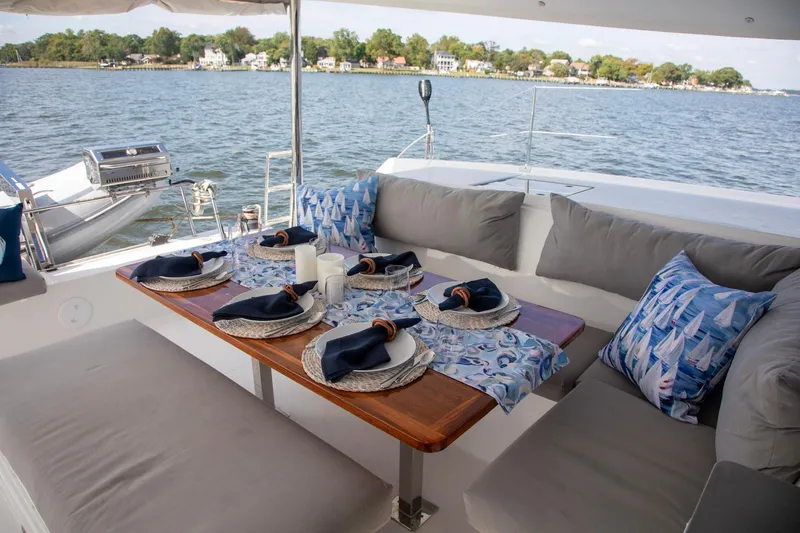 Slide: The Image of Luxurious dining setup on 2018 Fountaine Pajot Helia 44 Evolution catamaran, overlooking serene waters. - 22