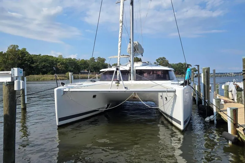 Slide: The Image of 2018 Fountaine Pajot Helia 44 Evolution catamaran docked in a serene marina setting. - 4