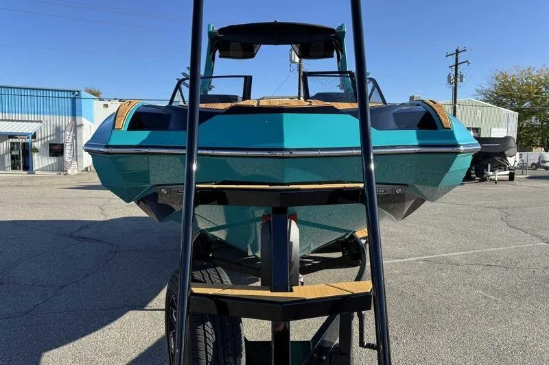 Slide: The Image of 2026 Supra SE boat on trailer, teal color, parked outdoors. - 4