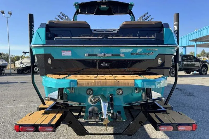 Slide: The Image of 2026 Supra SE boat rear view with teal and black design, parked outdoors. - 6