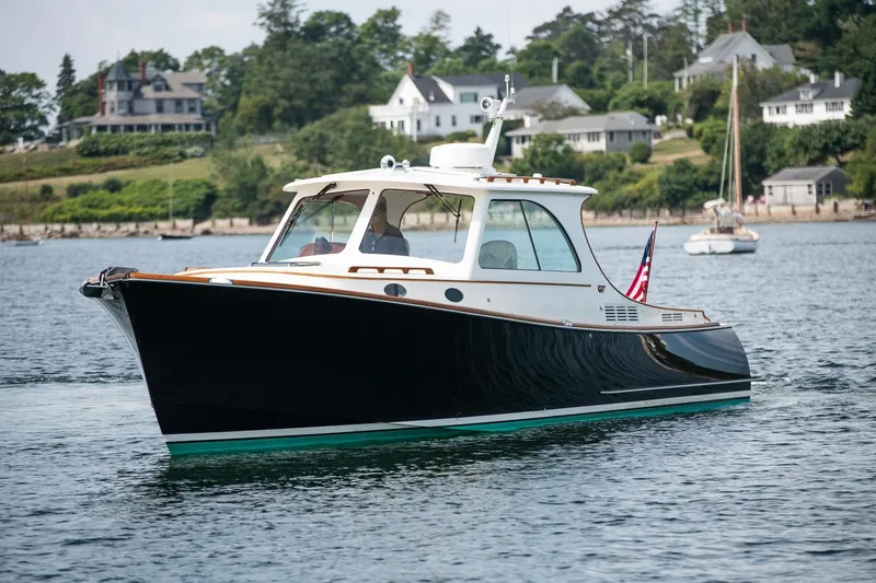 Slide: The Image of 2015 Hinckley Picnic Boat 37 MKIII cruising on a scenic waterfront. - 1
