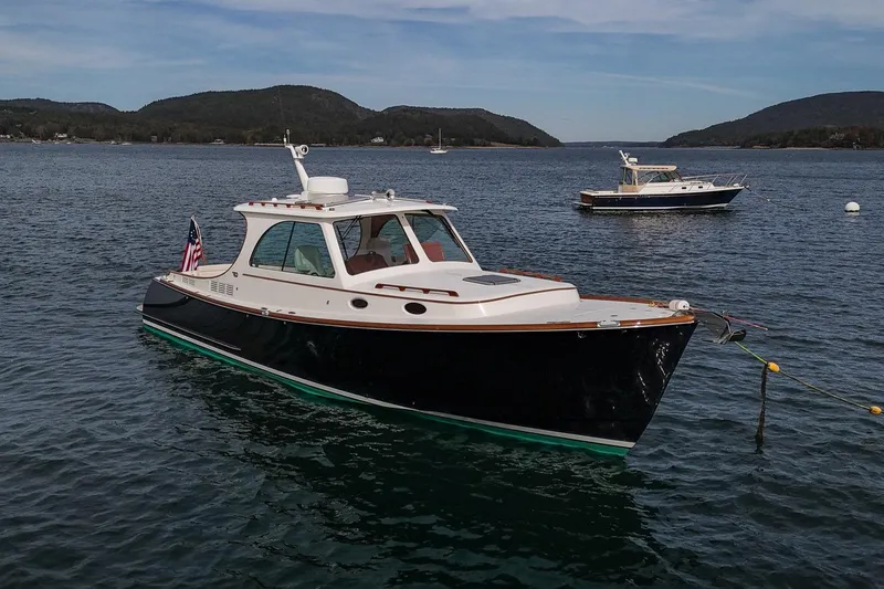 Slide: The Image of 2015 Hinckley Picnic Boat 37 MKIII on serene water with scenic hills in background. - 13