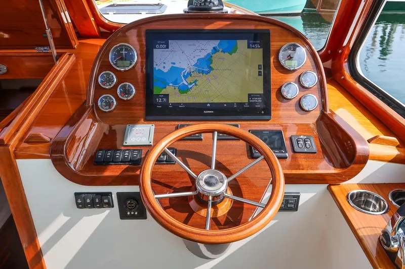 Slide: The Image of Helm of 2015 Hinckley Picnic Boat 37 MKIII with navigation display and wooden steering wheel. - 37