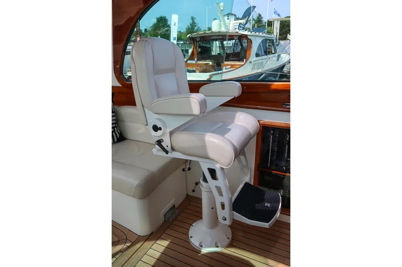 Slide: The Image of Captain's chair on 2015 Hinckley Picnic Boat 37 MKIII, featuring luxurious white leather upholstery. - 41
