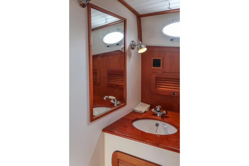 Slide: The Image of 2015 Hinckley Picnic Boat 37 MKIII bathroom with wooden vanity and mirror. - 47