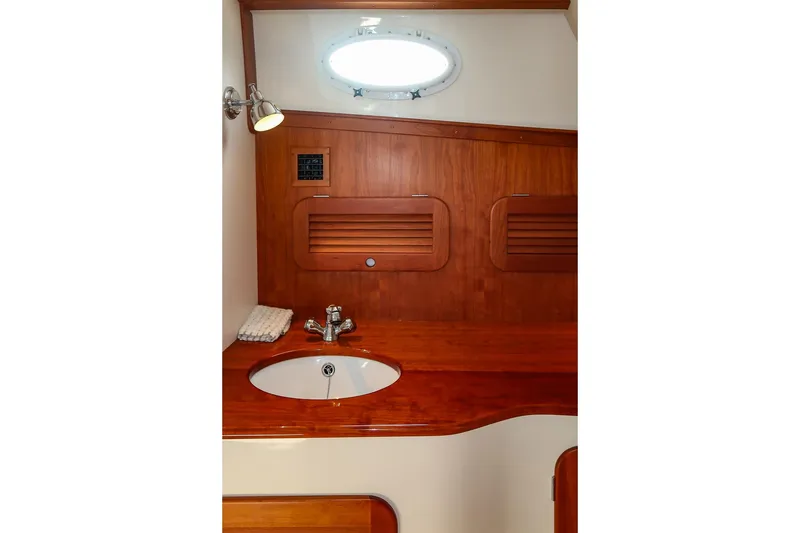 Slide: The Image of 2015 Hinckley Picnic Boat 37 MKIII bathroom with wooden cabinetry and round sink. - 48