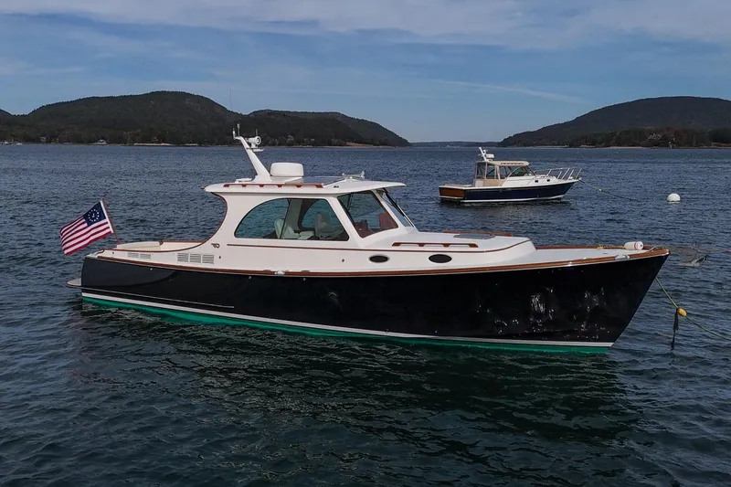 Slide: The Image of 2015 Hinckley Picnic Boat 37 MKIII on calm water with scenic mountain backdrop. - 14