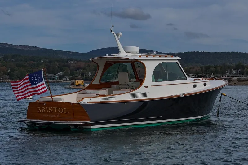 Slide: The Image of 2015 Hinckley Picnic Boat 37 MKIII on water, displaying American flag, scenic background. - 15