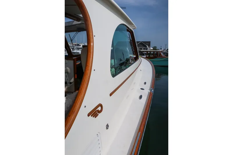 Slide: The Image of 2015 Hinckley Picnic Boat 37 MKIII with elegant wood trim, docked in a marina. - 23