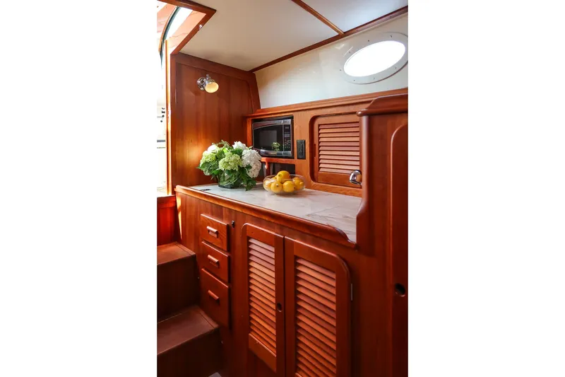 Slide: The Image of Interior of 2015 Hinckley Picnic Boat 37 MKIII with wooden cabinetry and countertop decor. - 42