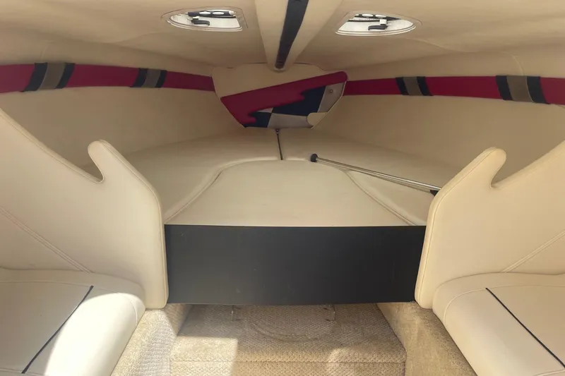 Slide: The Image of 2001 Rinker 262 Captiva boat interior with beige seating and red accents. - 15
