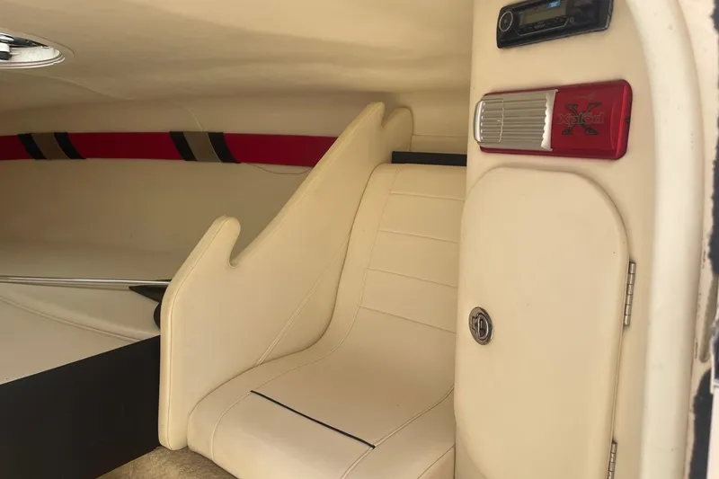Slide: The Image of Interior of a 2001 Rinker 262 Captiva boat, featuring beige seating and audio system. - 16