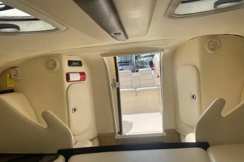 Slide: The Image of 2001 Rinker 262 Captiva boat interior with beige seating and open cabin door. - 18