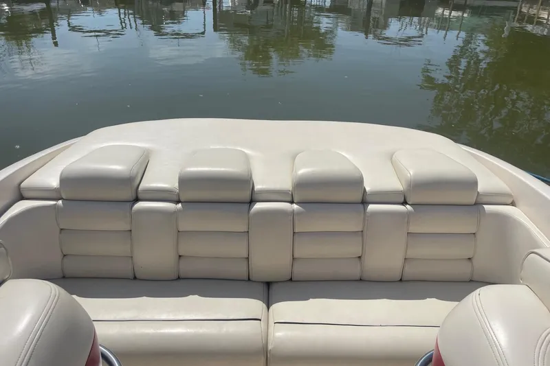 Slide: The Image of 2001 Rinker 262 Captiva boat interior with beige leather seating by the water. - 6