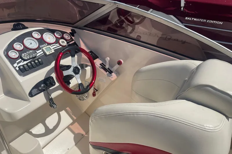 Slide: The Image of 2001 Rinker 262 Captiva boat dashboard with red steering wheel and gauges. - 7