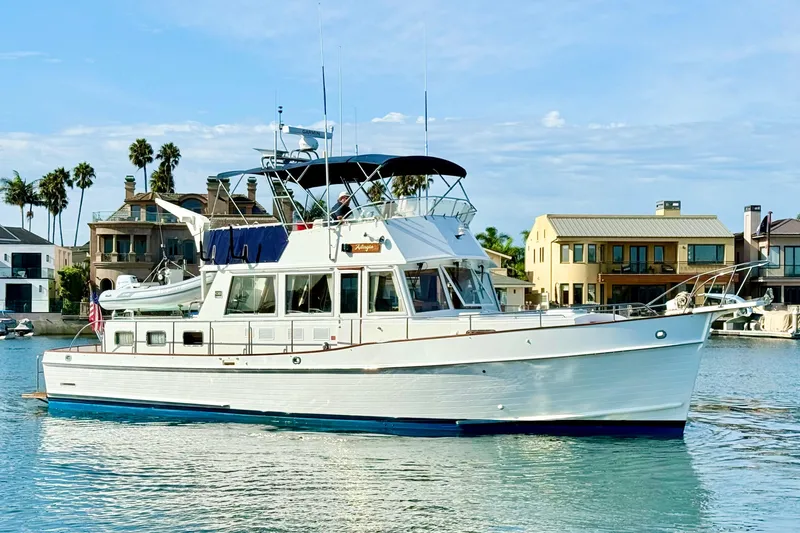 The Image of 2001 Grand Banks 46 Classic yacht on calm water, with waterfront homes in the background. - 0