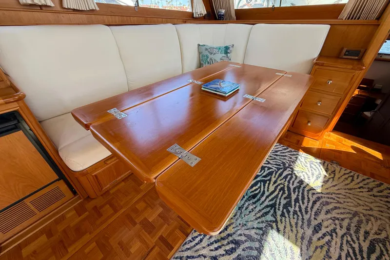 Slide: The Image of Interior of 2001 Grand Banks 46 Classic yacht with wooden table and cushioned seating. - 19