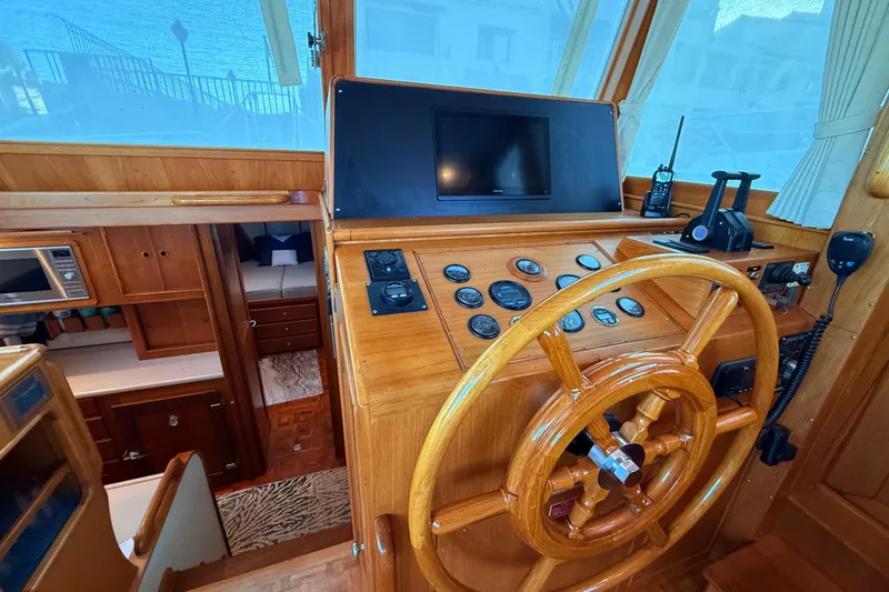 Slide: The Image of Helm of 2001 Grand Banks 46 Classic yacht with wooden wheel and navigation instruments. - 21