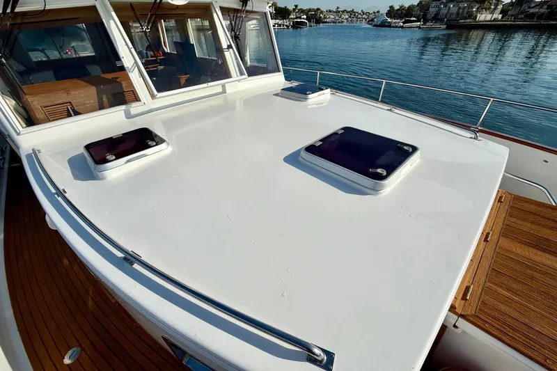 Slide: The Image of 2001 Grand Banks 46 Classic yacht deck with hatches, overlooking serene waterfront. - 39