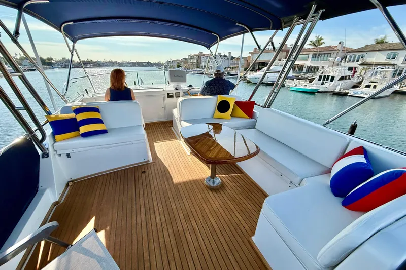 Slide: The Image of Luxurious 2001 Grand Banks 46 Classic yacht interior with colorful cushions and scenic marina view. - 48