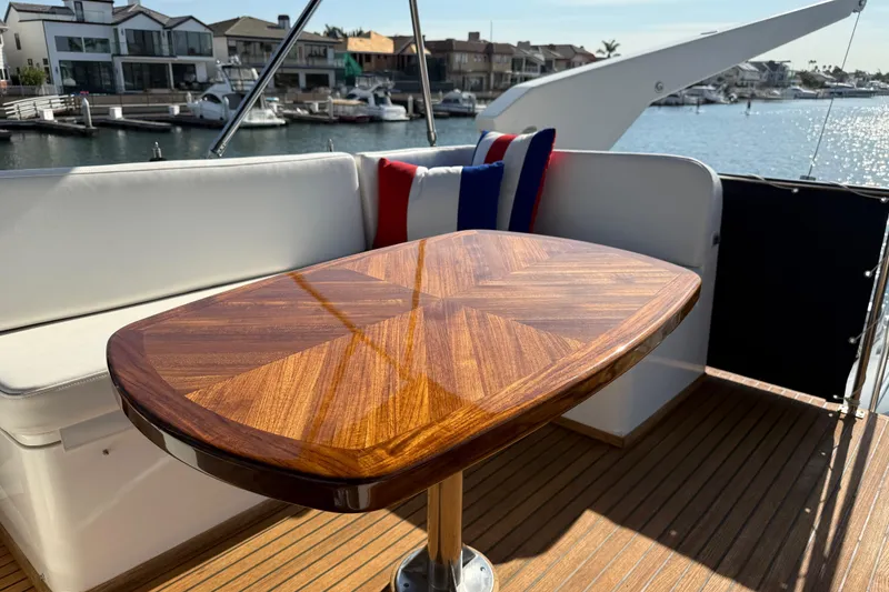 Slide: The Image of Luxurious 2001 Grand Banks 46 Classic yacht deck with polished wooden table and waterfront view. - 51