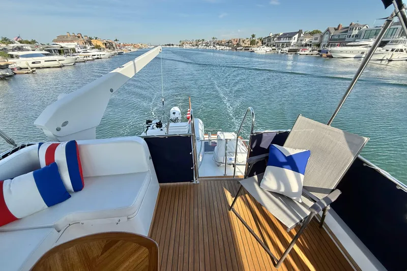 Slide: The Image of Grand Banks 46 Classic 2001 yacht deck with seating, cushions, and scenic waterfront view. - 52