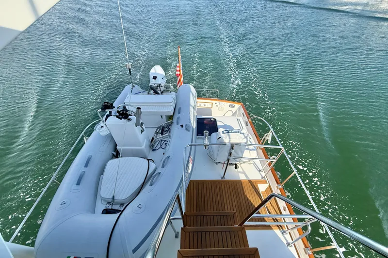 Slide: The Image of Grand Banks 46 Classic yacht deck with dinghy, cruising on calm waters, 2001 model. - 53