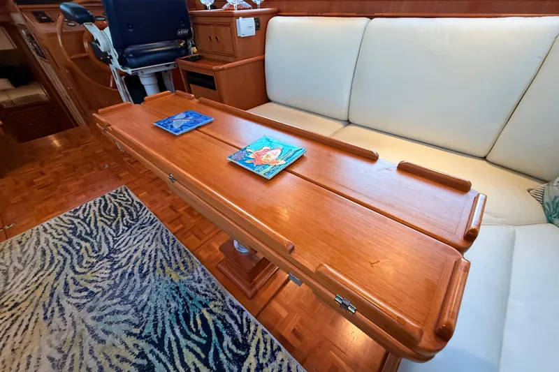 Slide: The Image of Interior of 2001 Grand Banks 46 Classic yacht with wooden table and cushioned seating. - 56