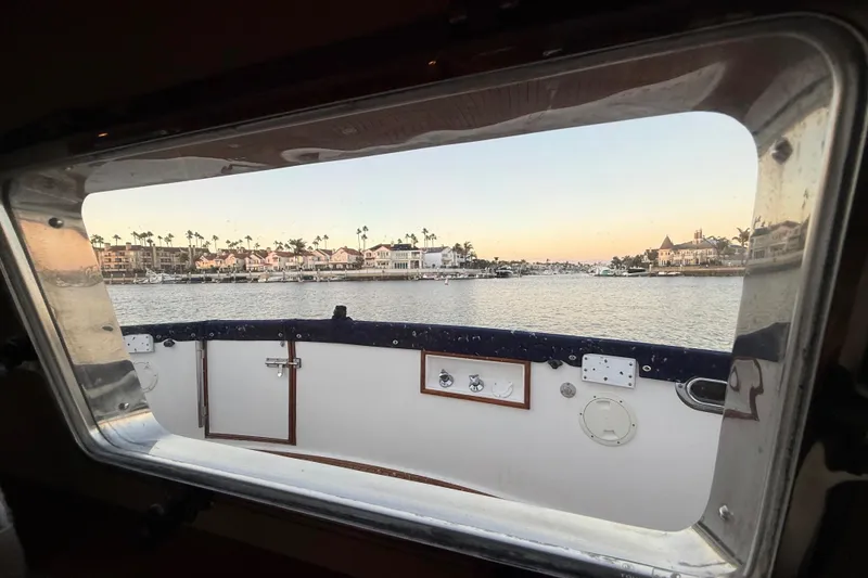 Slide: The Image of View from a 2001 Grand Banks 46 Classic yacht window overlooking a serene waterfront. - 63