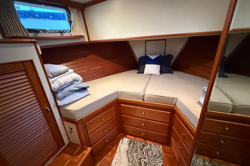 Slide: The Image of Cozy cabin interior of 2001 Grand Banks 46 Classic yacht with wooden cabinetry and bedding. - 64