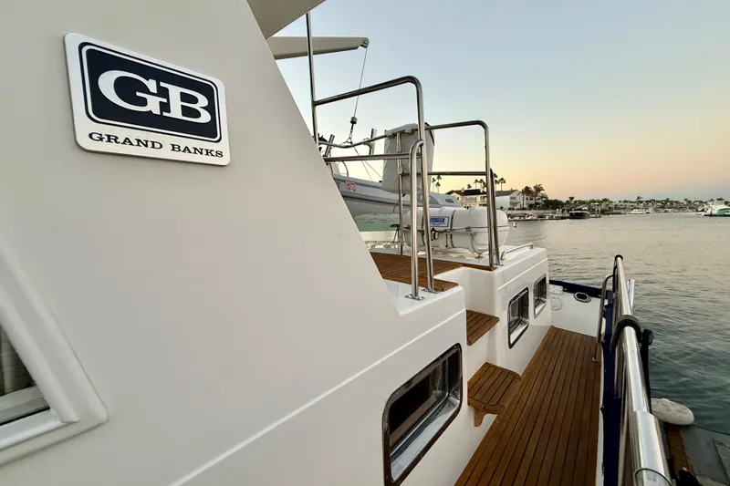 Slide: The Image of Grand Banks 46 Classic yacht, 2001 model, docked at sunset with wooden deck. - 77