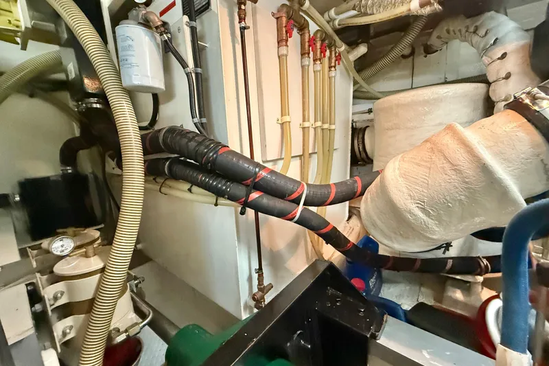 Slide: The Image of Engine room of 2001 Grand Banks 46 Classic yacht, showing hoses and mechanical components. - 84