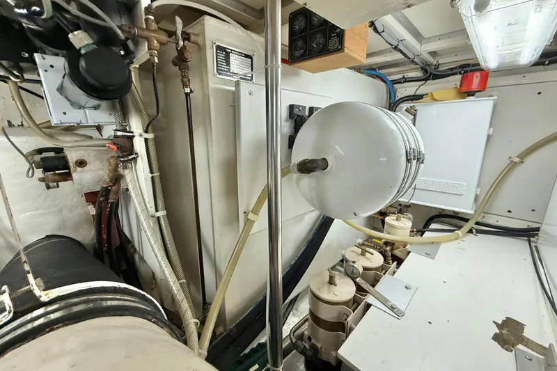 Slide: The Image of Engine room of 2001 Grand Banks 46 Classic yacht, showcasing mechanical components and piping. - 86