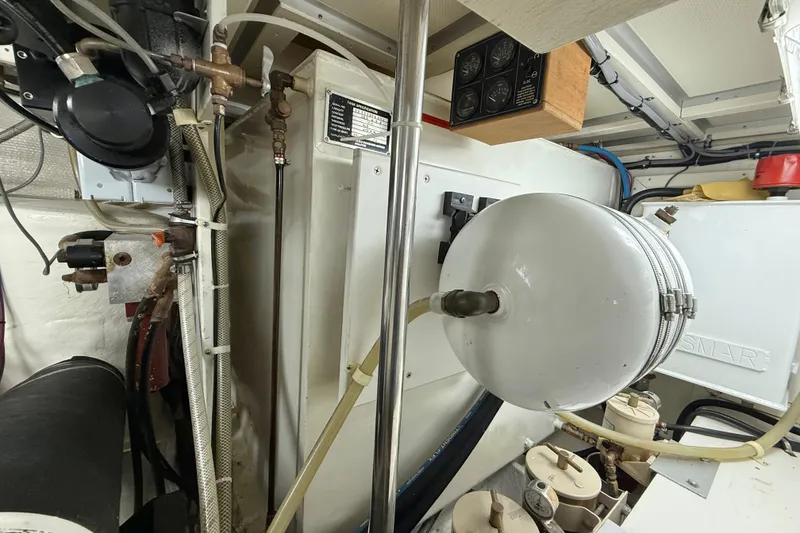 Slide: The Image of Engine room of 2001 Grand Banks 46 Classic yacht, featuring mechanical components and piping. - 92